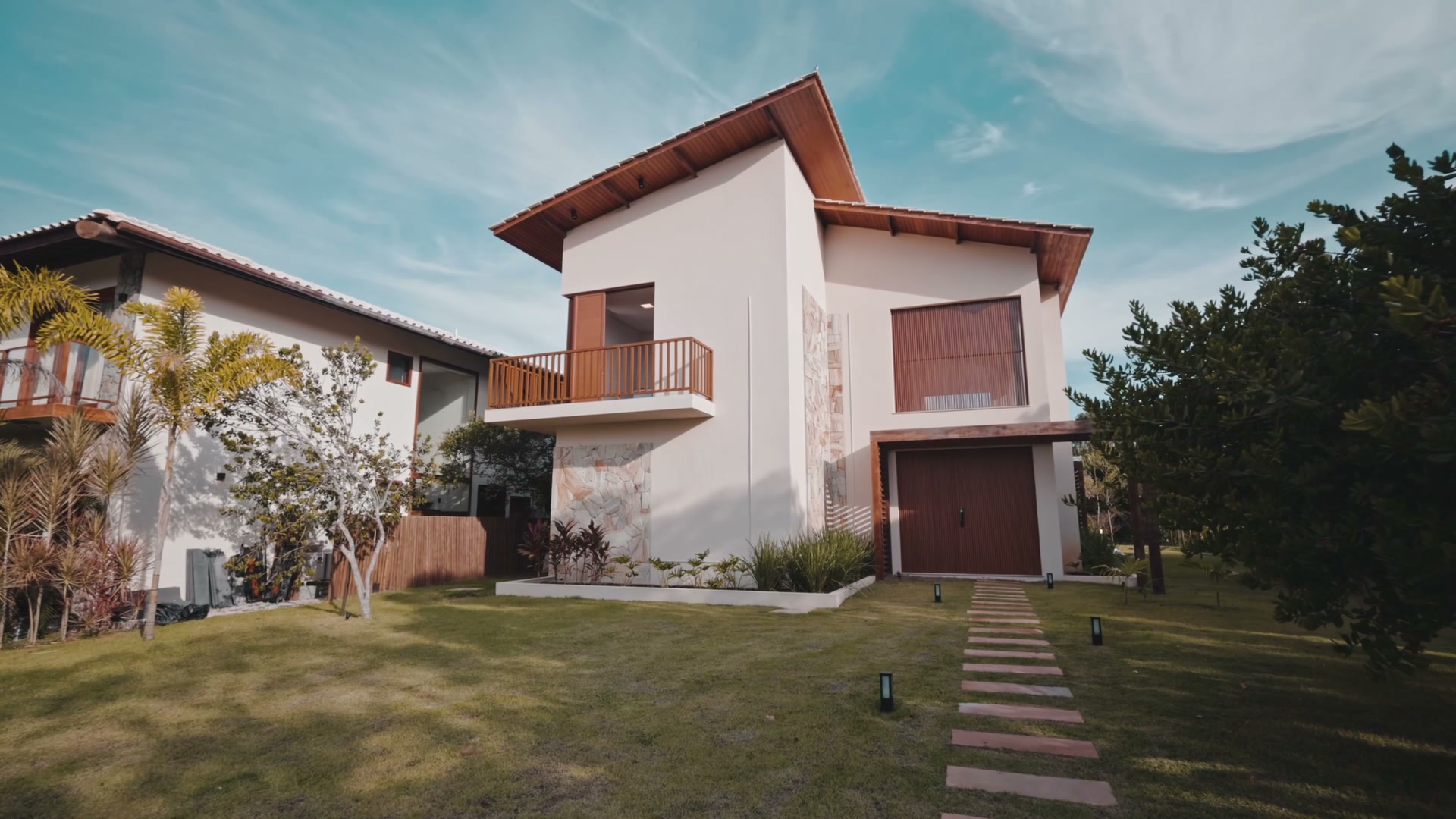 A residence with white walls, warm wood and a landscaped courtyard.